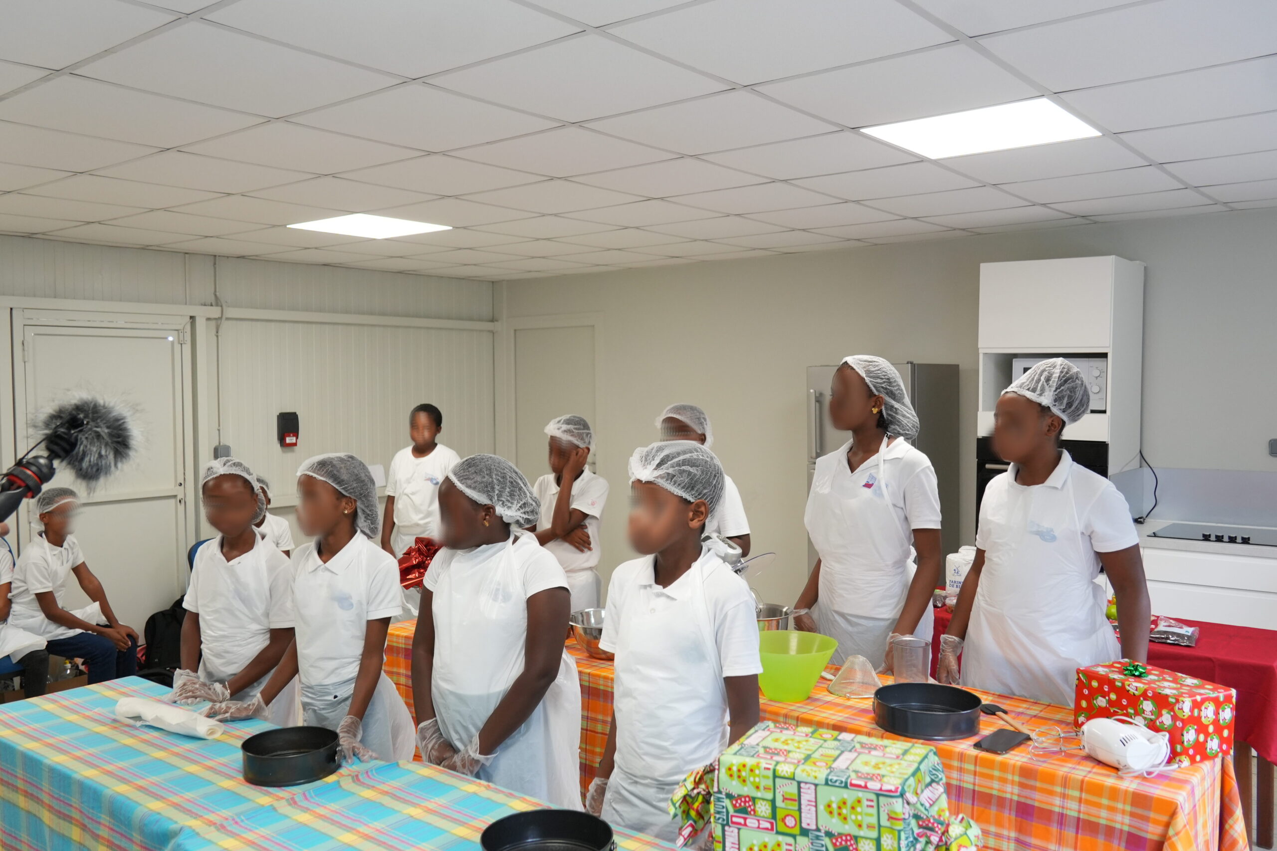 Le groupe d'élèves écoute attentivement les instructions de préparation du Black Cake.